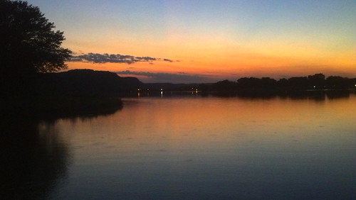Lake Winona at dusk: an orange sunset sky is reflected in the waters of a lake. The trees around the lake are in silhouette.