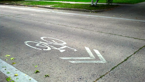 A sharrow painted on the street: A bicycle symbol accompanied by a pair of chevrons.